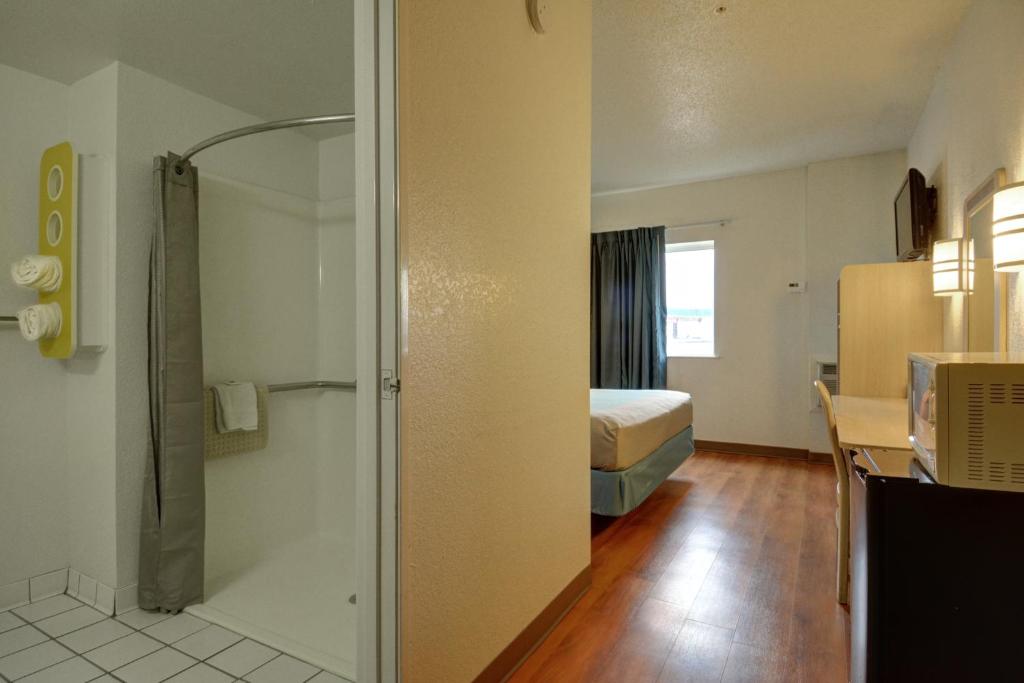 a hotel room with a bed and a shower at Motel 6-Denison, TX in Denison