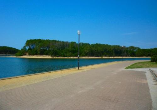 a empty street next to a body of water at Pavillon, de 4 à 7 couchages, dans une superbe résidence avec piscine in Soustons