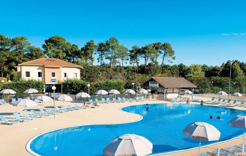 a large swimming pool with chairs and umbrellas at Pavillon, de 4 à 7 couchages, dans une superbe résidence avec piscine in Soustons