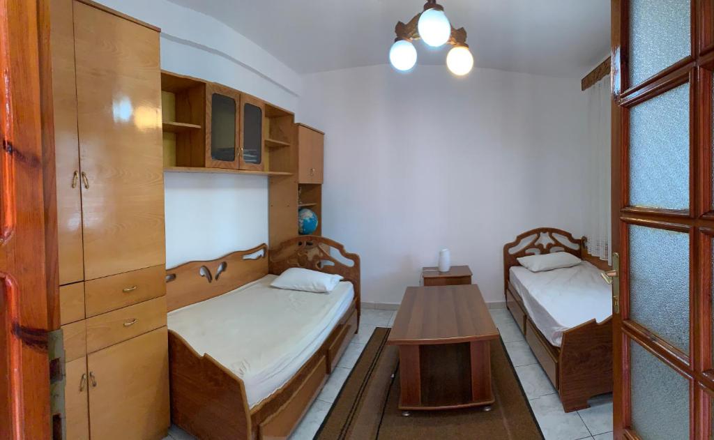 a room with two beds and a table in it at Shtepi Me qera Fier in Fier