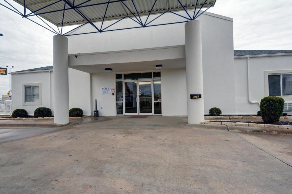 a large white building with a large entrance at Motel 6-Denison, TX in Denison