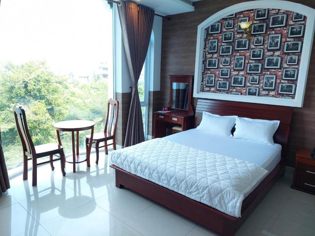 um quarto com uma cama, uma mesa e uma janela em Biển Vàng - New Golden Sea em Vung Tau