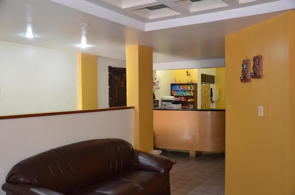 a waiting room with a leather couch and a counter at Hotel Vivo in Garanhuns