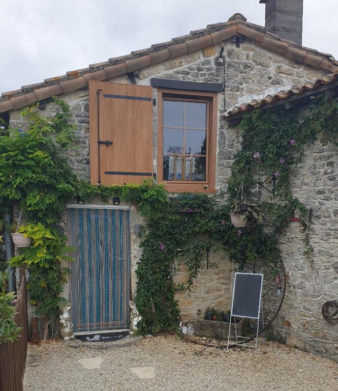 a stone house with a window and a door at Chocolate Box Cottage in Parzac