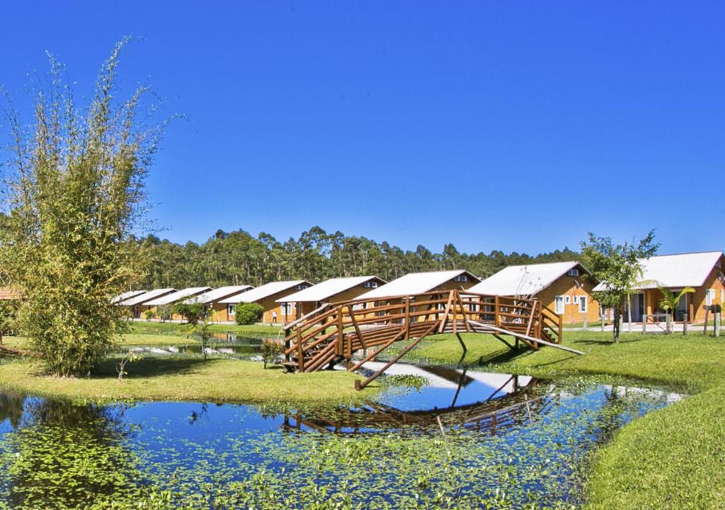 um resort com uma ponte sobre uma massa de água em Hotel Acqua Lokos em Capão da Canoa