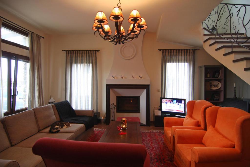 sala de estar con muebles de color naranja y chimenea en A luxury mansion near Kerkini lake (Villa Oriana), en Kerkíni