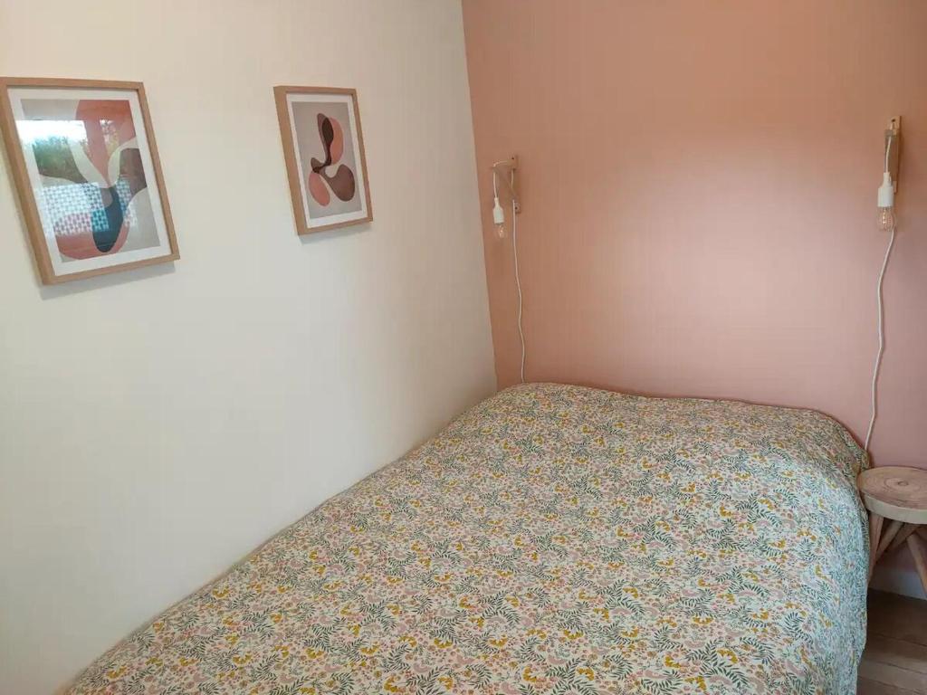 1 dormitorio pequeño con 1 cama y 2 cuadros en la pared en Maisonnette proche plage Saint-Malo en Saint-Malo
