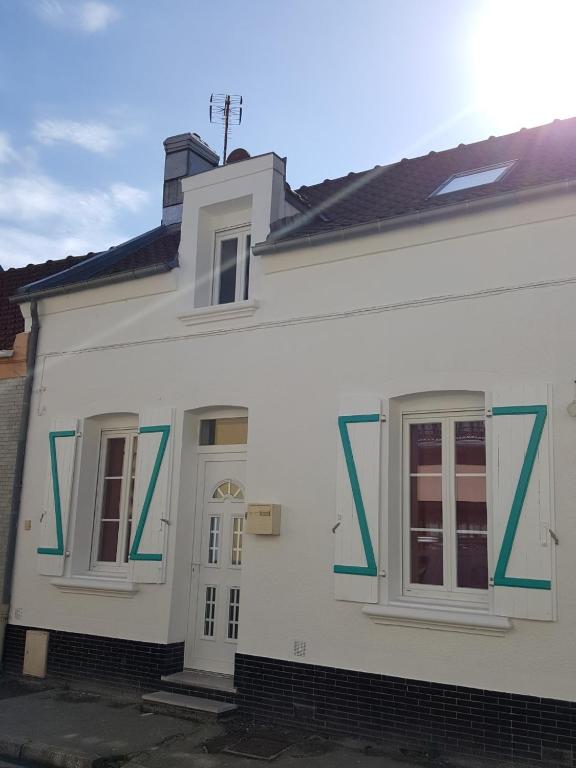 une maison blanche avec deux fenêtres et une porte dans l'établissement La Belle Etaploise, à Étaples