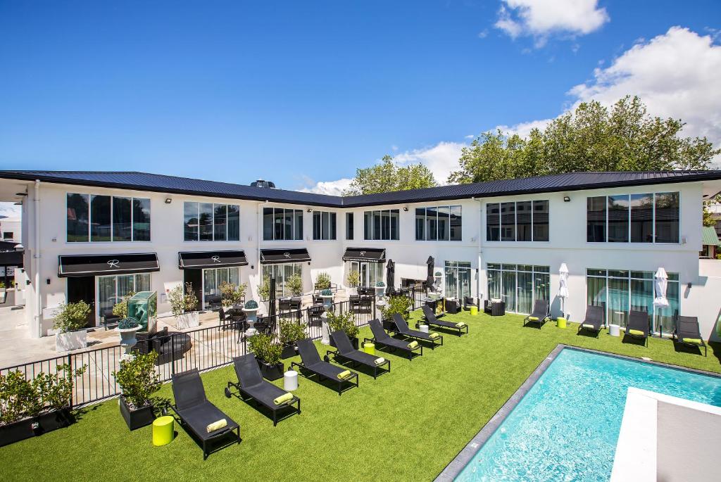 uma vista exterior de um edifício com cadeiras e uma piscina em Regent of Rotorua Boutique Hotel em Rotorua