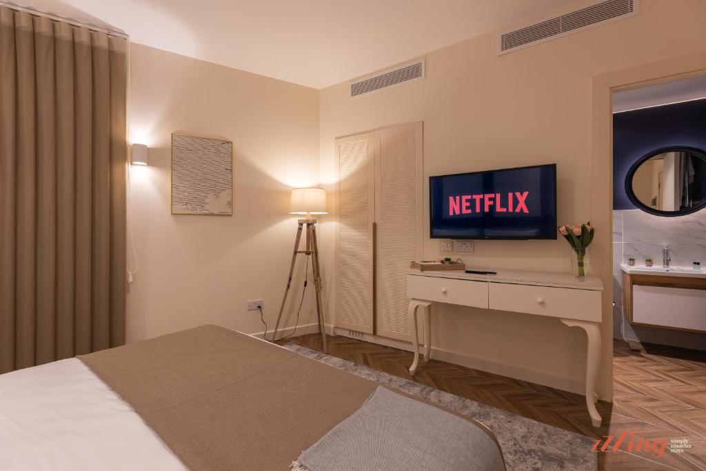 a hotel room with a bed and a television at El Doris Boutique Living in Marsaskala