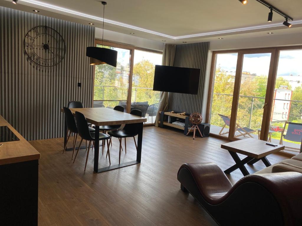 Apartament Grey Love w Czeladzi, FV, 8km do Katowic في تشيلادز: غرفة معيشة مع طاولة وكراسي وأريكة