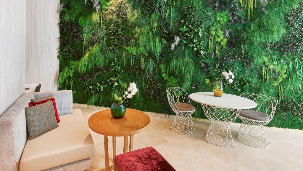 a living room with a green wall with a table and chairs at NH Collection Marseille in Marseille