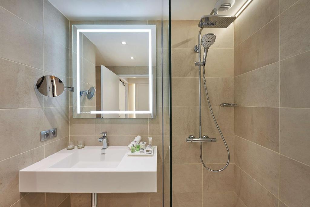 a bathroom with a sink and a shower at NH Collection Marseille in Marseille