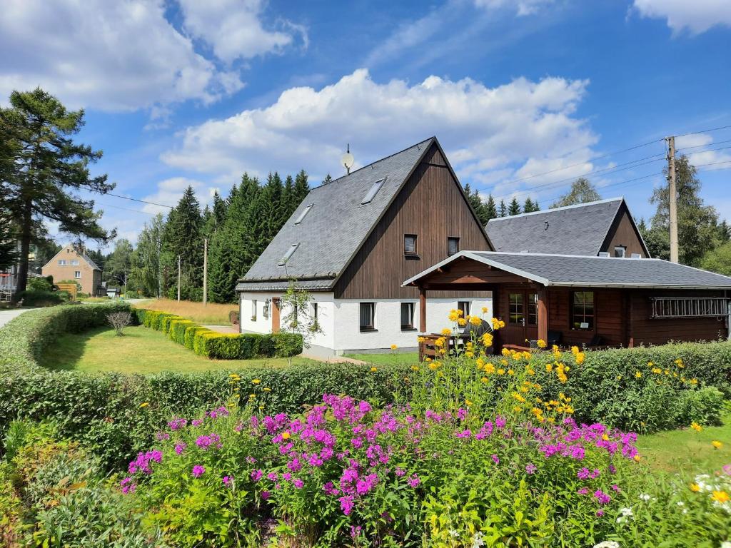 a barn with a field of flowers in front of it at Ferienhaus Erzgebirge in Marienberg