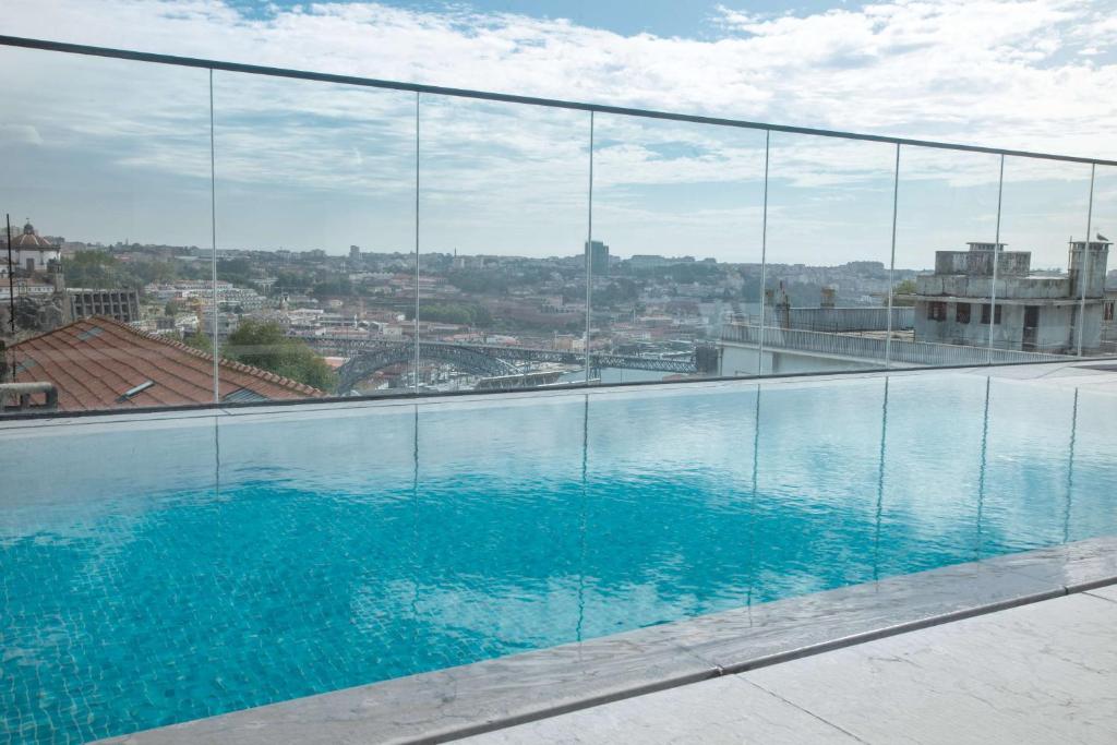 a swimming pool with a view of a city at NH Porto Jardim in Porto