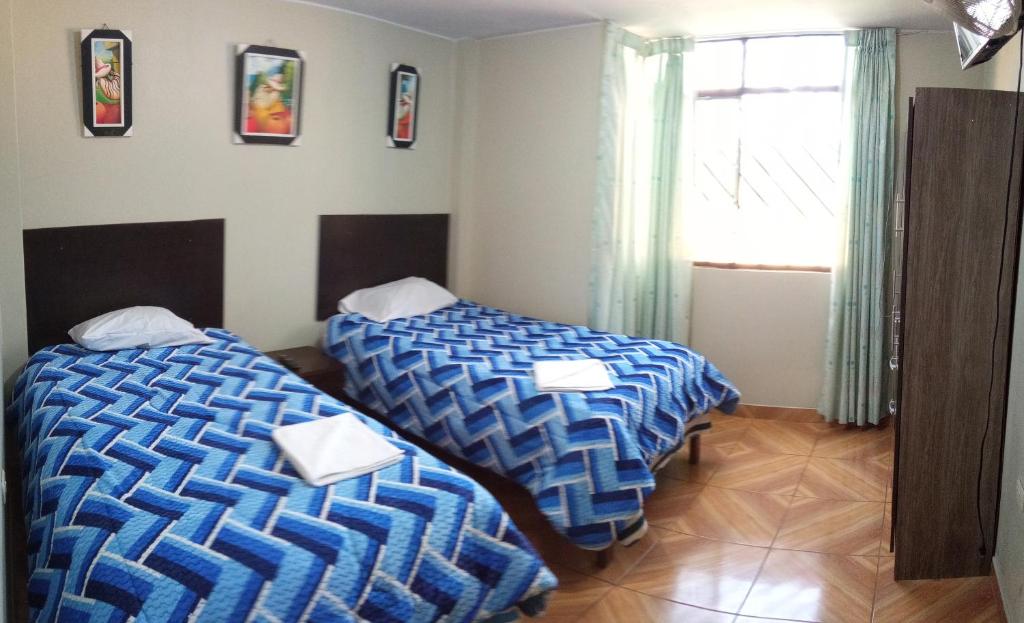 a room with two beds and a window at LUANA’S HOUSE in Ica