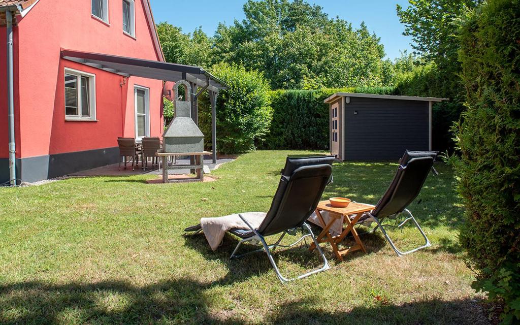 ブレーゲにあるFamilienfreundliche Fewo "Strandtiger" mit Terrasse, Garten und Wlan, 500m bis zum Traumstrandの家庭の椅子2脚とテーブル