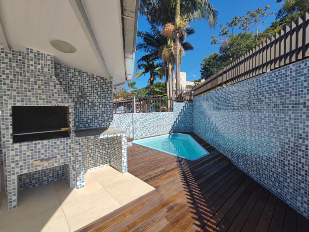 una piscina en una casa con una pared de azulejos en DS2 - 2 Dorm PIscina AR WIFI Churrasqueira - BRUNO KLEMTZ, en Itapema