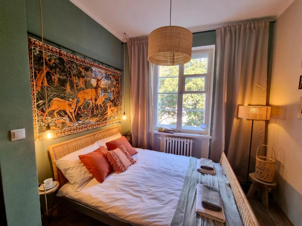 um quarto com uma cama com um quadro na parede em Cozy&Retro - Old Town Apartament em Gdansk