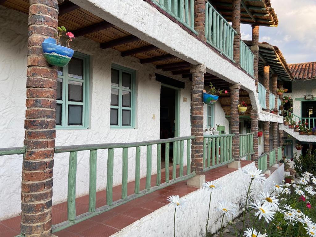 een huis met een balkon met bloemen ervoor bij Apartamento En Pueblito Boyacense in Duitama