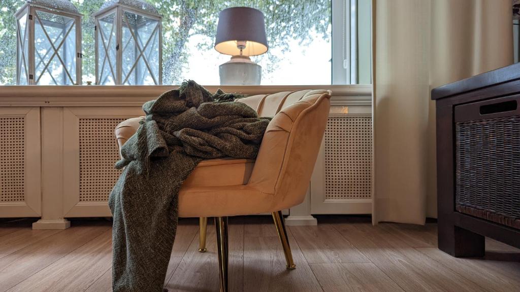 ロッテルダムにあるCRASH'NSTAY - Maison du Villeのリビングルームの椅子に座る毛布