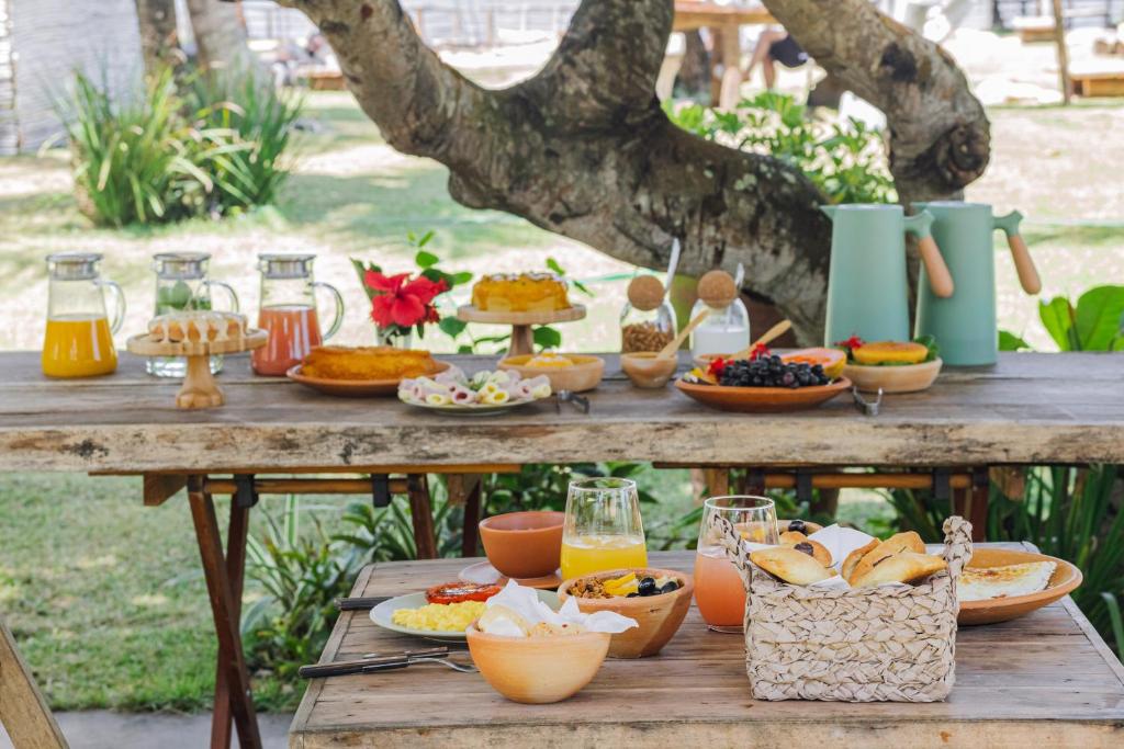 a picnic table with food and drinks on it at Pousada Quintal Caraíva in Caraíva