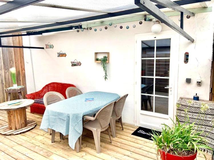 a patio with a table and chairs on a deck at Maisonnette Bassin d'Arcachon in La Teste-de-Buch