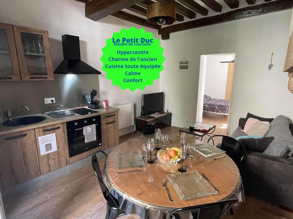 een keuken en een tafel in de woonkamer bij Le Petit Duc in Dijon