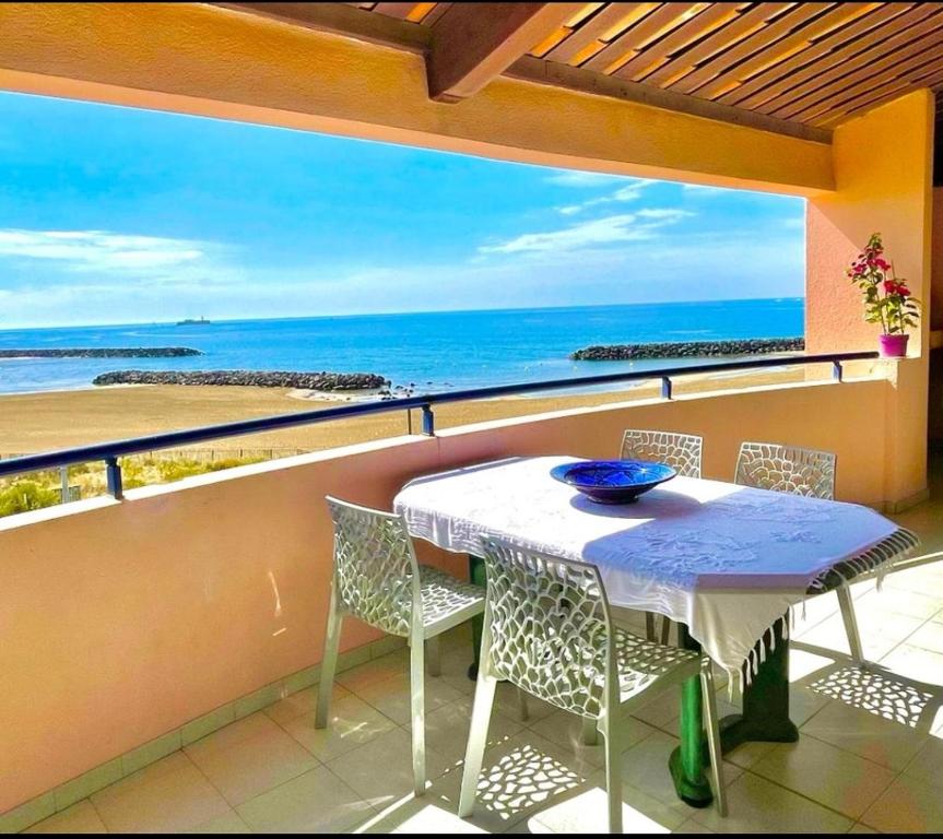 a table and chairs on a balcony with a view of the ocean at Savanna Beach in Cap d'Agde