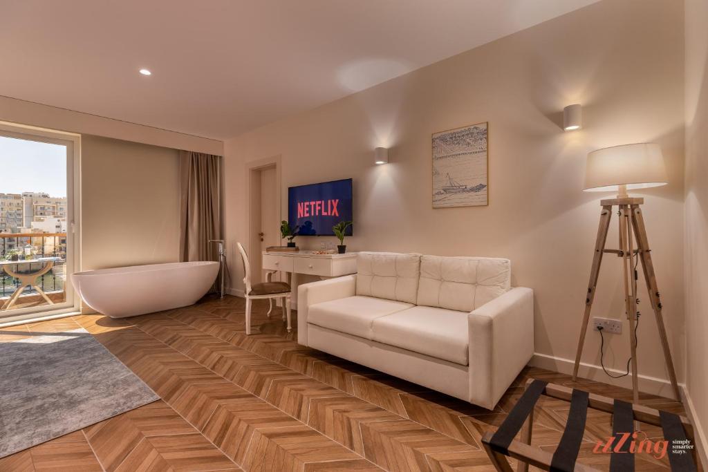 a living room with a white couch and a desk at El Doris Boutique Living in Marsaskala