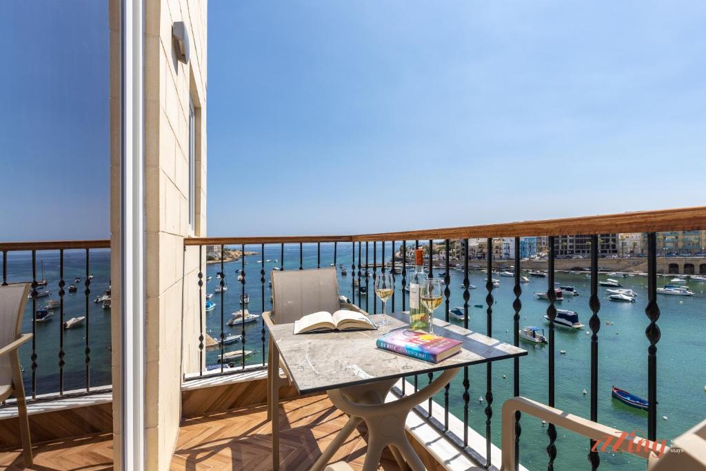 a balcony with a table and a view of a harbor at El Doris Boutique Living in Marsaskala
