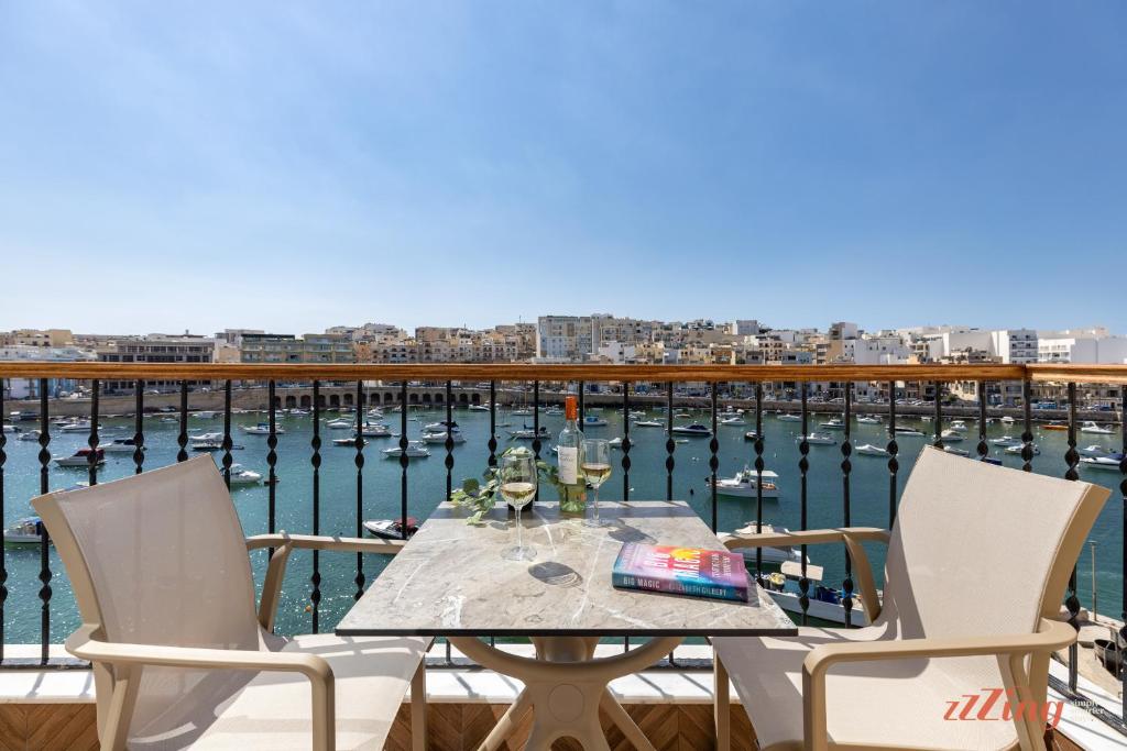 a table with two chairs and a view of the water at El Doris Boutique Living in Marsaskala