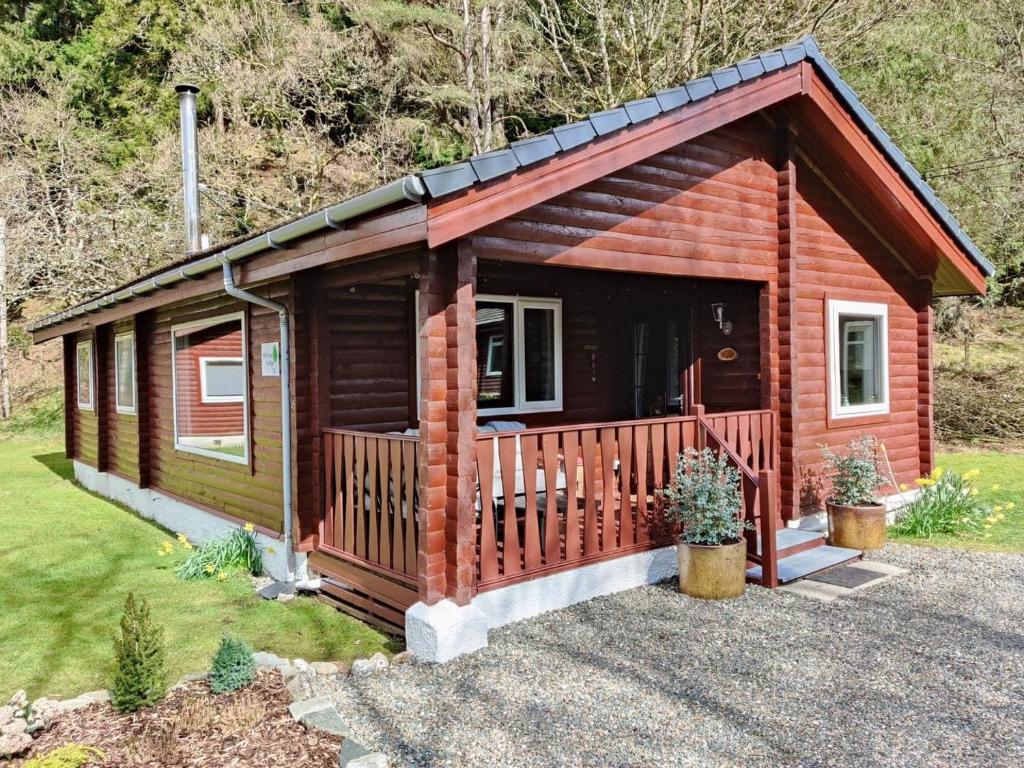 a small log cabin with a porch at Willow Lodge in Rashfield