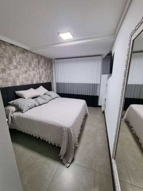 a bedroom with a bed and a large mirror at Loft silgar in Sanxenxo