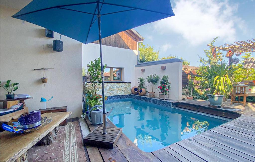 uma piscina com um guarda-sol ao lado de uma casa em Lovely Home In Mittelbergheim With Kitchen em Mittelbergheim