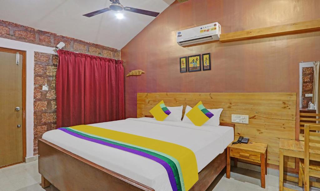 a bedroom with a large bed with a colorful blanket at Itsy By Treebo - Kings L Den Homestay in Mysore
