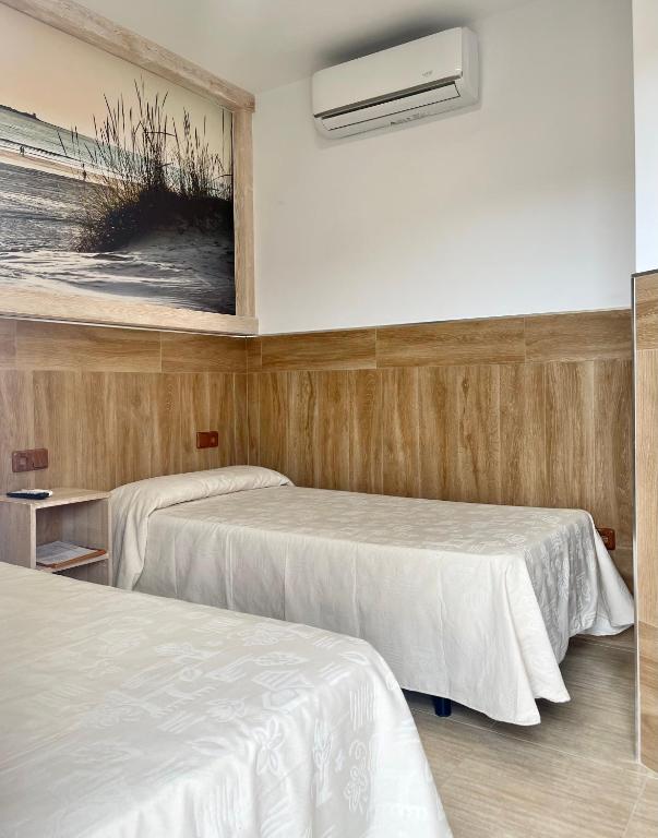 Łóżko lub łóżka w pokoju w obiekcie Hostal Noli