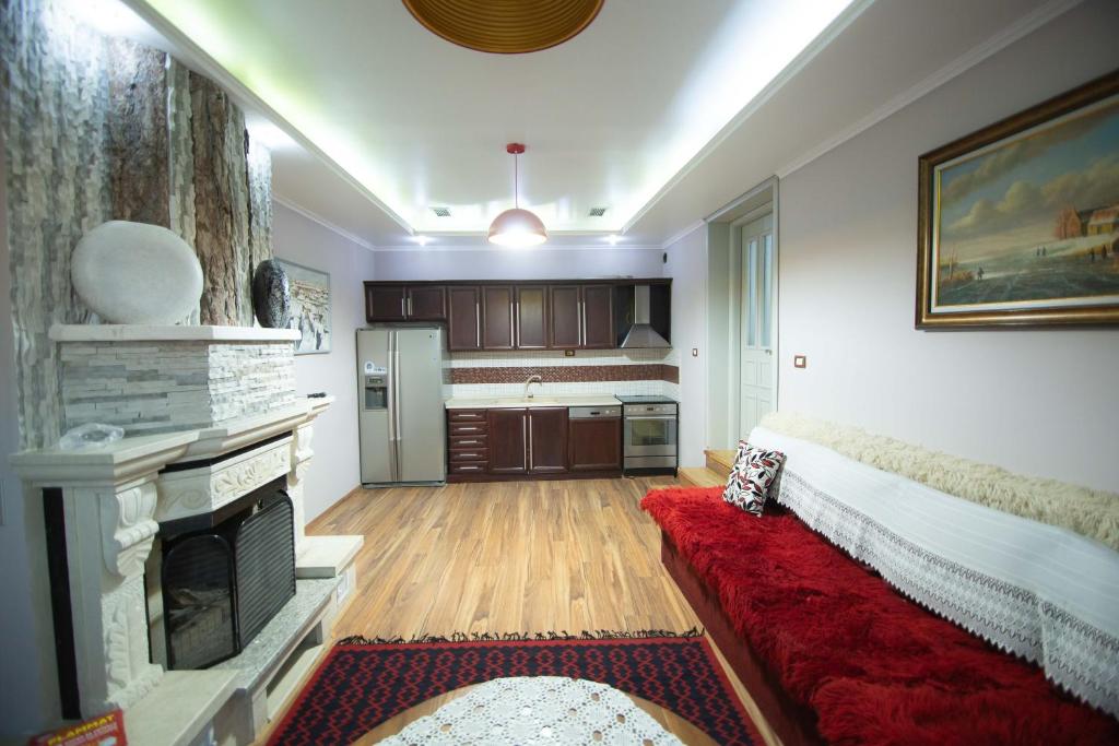 a living room with a fireplace and a red couch at Vila Mariss in Korçë