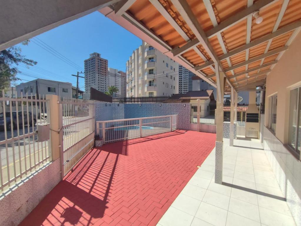 balcón de un edificio con suelo rojo en DS1 - CASA COM PISCINA PRIVATIVA - 2 dorm - PRAIA DE MEIA PRAIA - BRUNO KLEMTZ, en Itapema