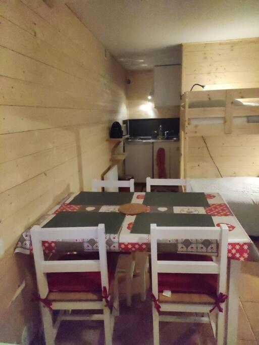 a room with a table and chairs and a kitchen at Très joli Studio refait à neuf au calme in Saint-Martin-Vésubie