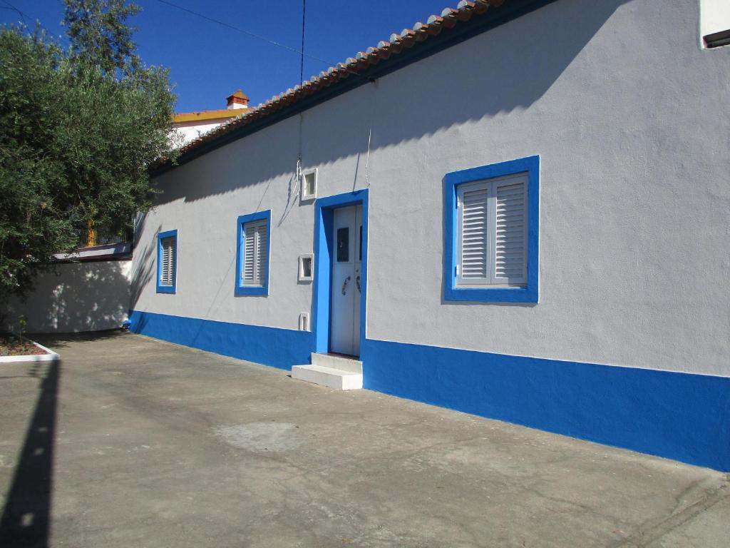 un bâtiment bleu et blanc avec une porte bleue dans l'établissement CASA DA ALDEIA - Ponte de Sor (Alentejo), à Ponte de Sor