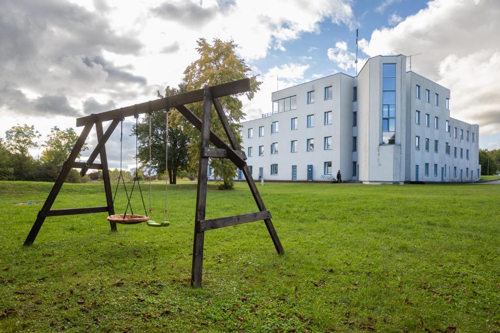 a swing set in a field in front of a building at Mereranna apartment 5 in Kuressaare