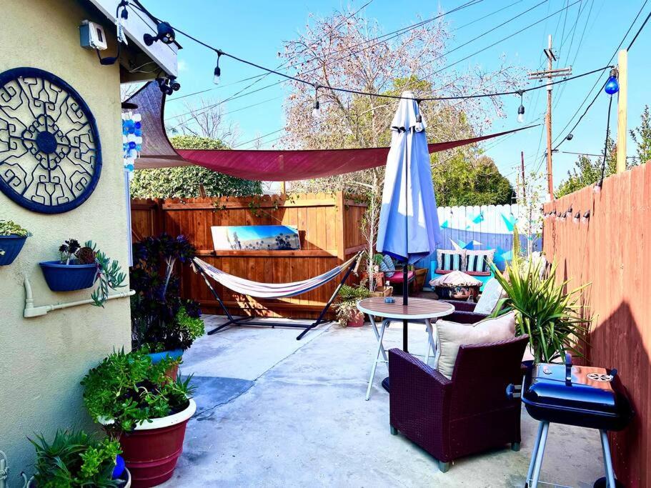 un patio con hamaca y un reloj en una valla en Hidden Gem LA: 2bd guesthouse w/ dreamy backyard, en Encino
