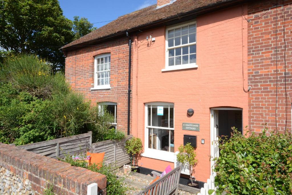 a brick house with a fence in front of it at 6 Coastguard Cottages, Aldeburgh in Aldeburgh