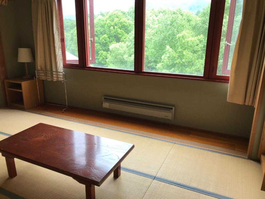 een woonkamer met een tafel en een groot raam bij Aizu Kogen International Human Resources Center - Vacation STAY 34905v in Minamiaizu
