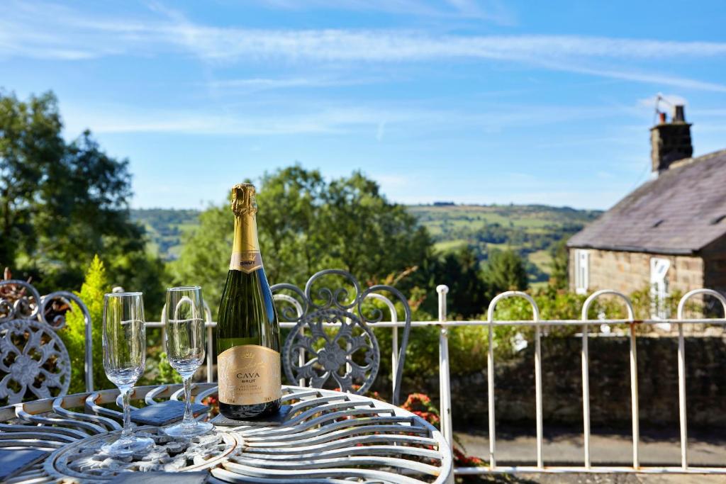 a bottle of wine sitting on a table with wine glasses at Finest Retreats - Peak View in Two Dales