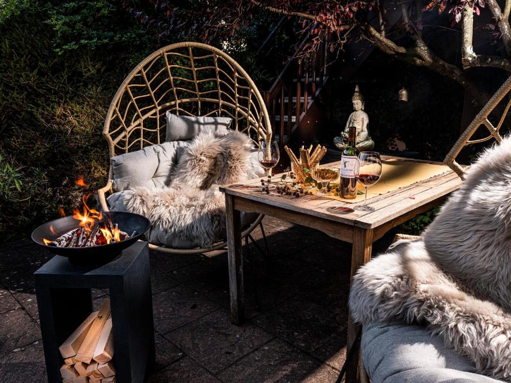 un patio con una mesa, un sofá y una mesa con en Homely Stay in a romantic lodging with sauna&gym, en Münsing