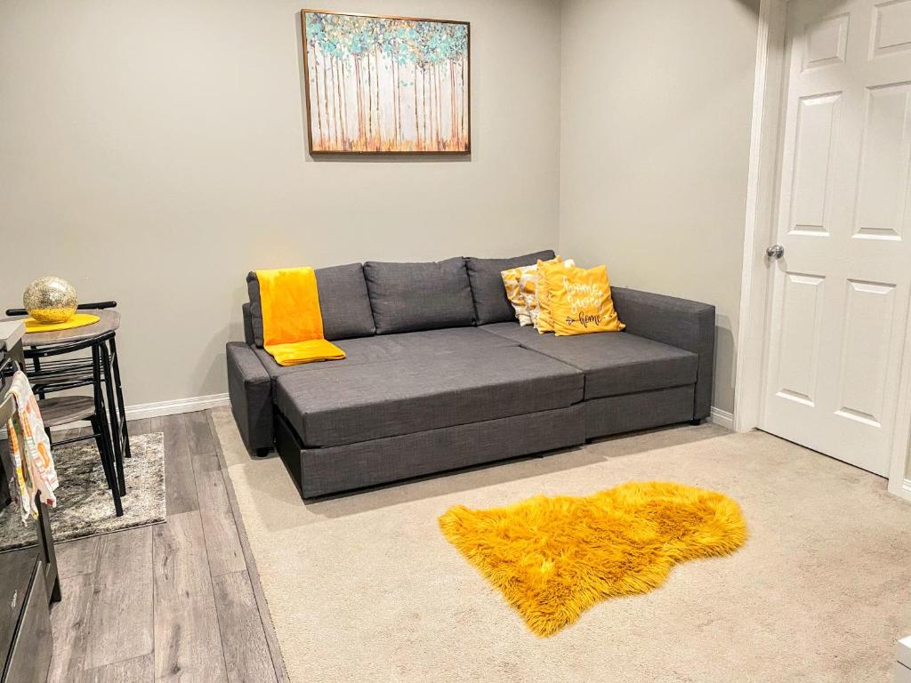 a living room with a gray couch and a yellow rug at Cozy Newly Built and Cheerful 1-Bedroom Suite in Calgary