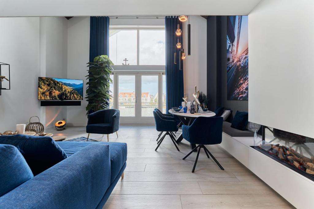 sala de estar con sofá azul y mesa en Captains Boathouse, en Harderwijk