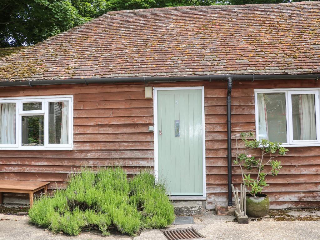 ein braunes Haus mit einer weißen Tür und Fenstern in der Unterkunft Byre Cottage 4 in Pulborough